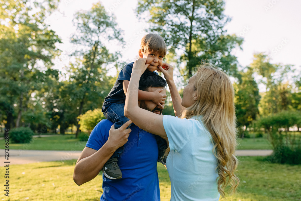 Fototapeta premium Parents play in the park with their son