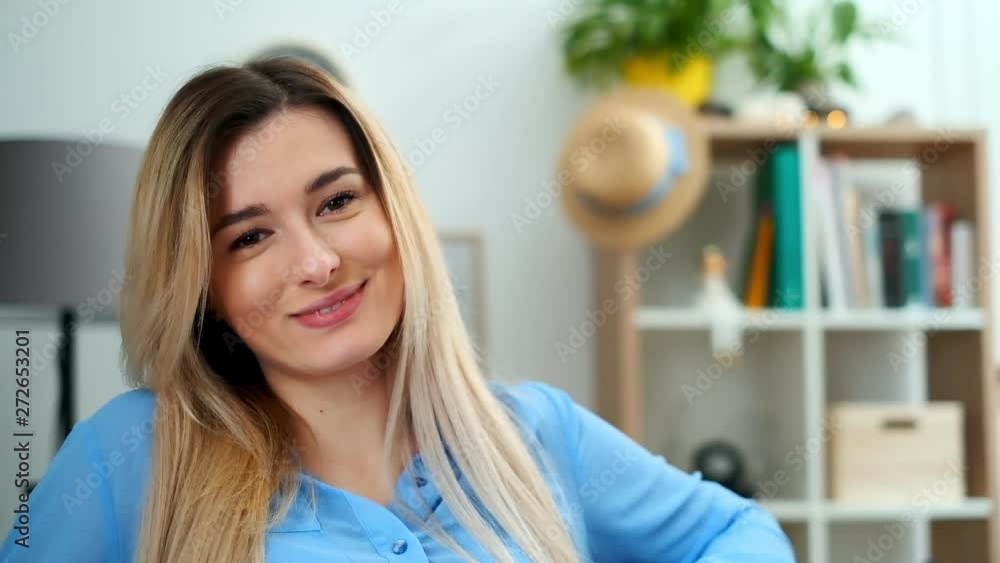 Wonderful smiling girl with a lovely look and natural make up looking at camera at cozy room. Close-up face portrait of young beautiful woman in blue outfit relaxing at home. Wonderful smiling girl with a lovely look and natural make up looking at camera at cozy room. Close-up face portrait of young beautiful woman in blue outfit relaxing at home.