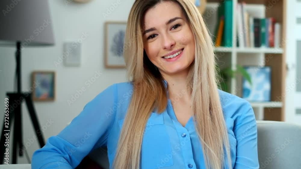 Wonderful smiling girl with a lovely look and natural make up looking at camera at cozy room. Close up face portrait of young beautiful woman in blue outfit relaxing at home. Wonderful smiling girl with a lovely look and natural make up looking at camera at cozy room. Close up face portrait of young beautiful woman in blue outfit relaxing at home.
