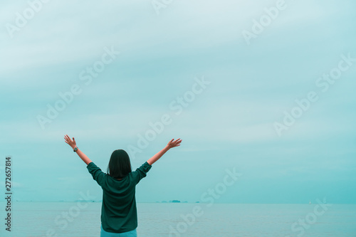 Woman rise hands up to sky freedom concept with blue sky.