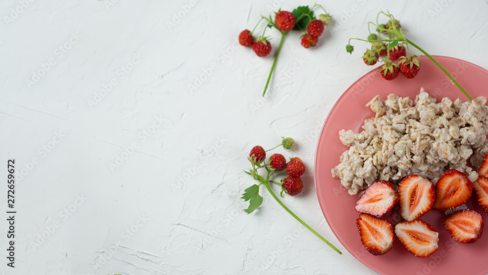 Oatmeal with strawberries on a white table . Healthy and tasty Breakfast Oatmeal with strawberries on a white table . Healthy and tasty Breakfast