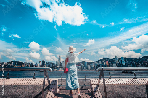 Canvas Print Asian woman wear straw hat look at Victoria Harbor from Tsim Sha Tsui