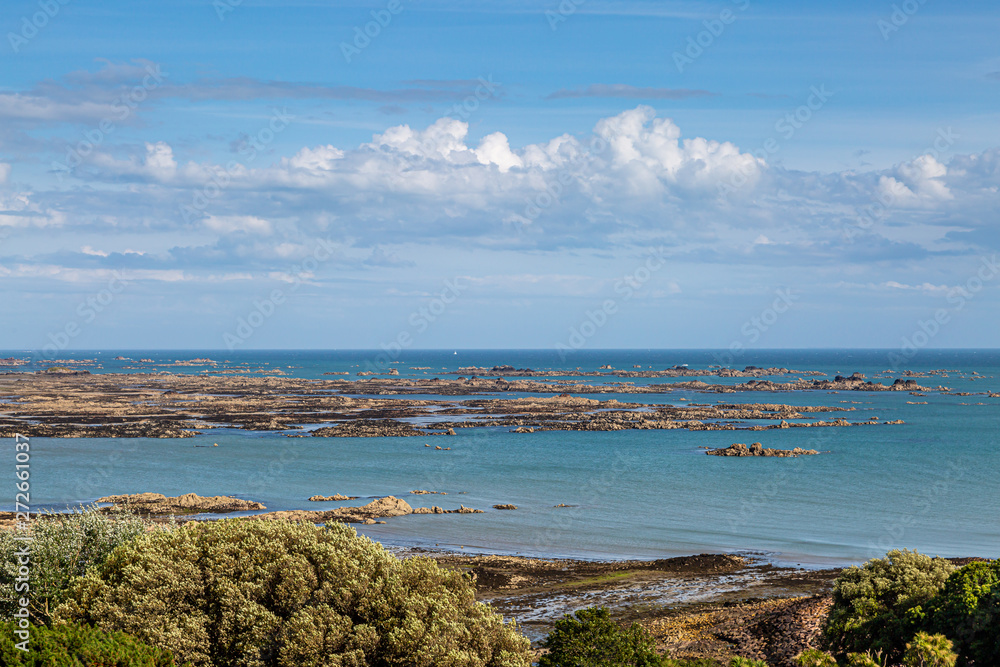 Looking out to a rocky coastal landscape on the island of Jersey, on a sunny summers day