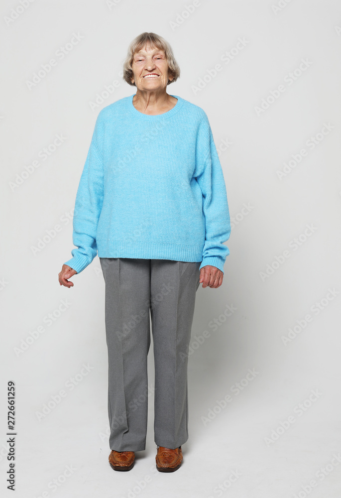 Full length portrait of a content senior lady smiling and looking at the camera Full length portrait of a content senior lady smiling and looking at the camera