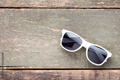 Fashion sunglasses on grey wooden table