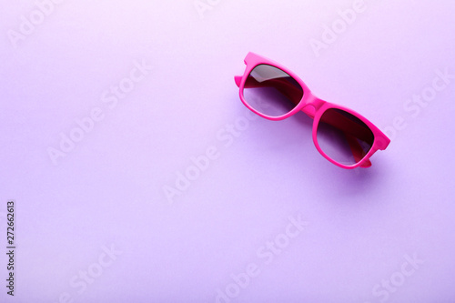Modern sunglasses on purple background