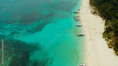 Travel concept: sand beach with tourists and turquoise water on Boracay, Philippines, aerial drone. Seascape with Puka shell beach on tropical island. Summer and travel vacation concept.