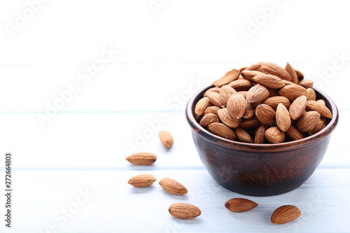 Almonds in bowl on white wooden table