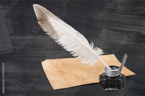 Feather quill pen and glass inkwell isolated on a white background