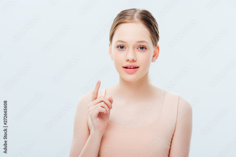 pretty teenage girl looking at camera and showing idea gesture isolated on grey pretty teenage girl looking at camera and showing idea gesture isolated on grey