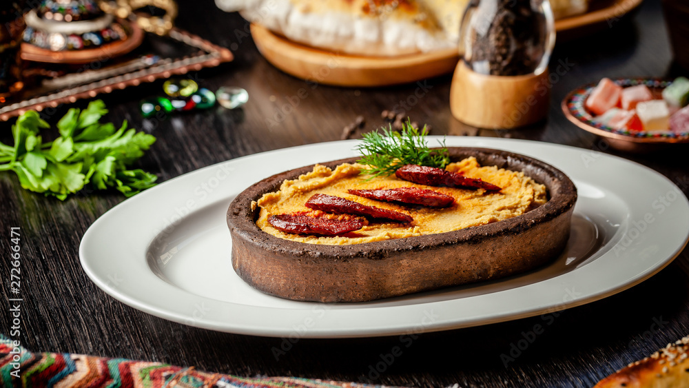 Traditional Turkish, Arabic cuisine. Hummus with salami sausage, in a