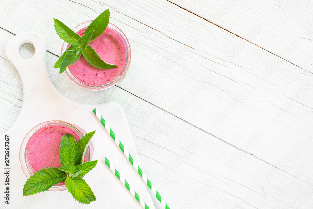 Εκτύπωση καμβά Background with two glasses of berry smoothies on the white wooden table