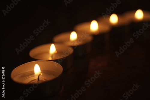 rows of lit candles in the church 