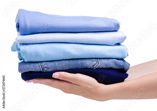 Stack blue folded clothing in hand on white background isolation