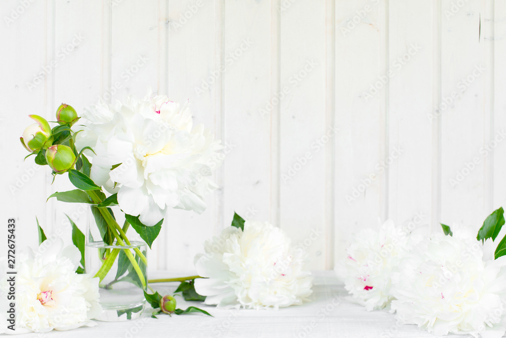 White tender background with peonies on the wooden table White tender background with peonies on the wooden table