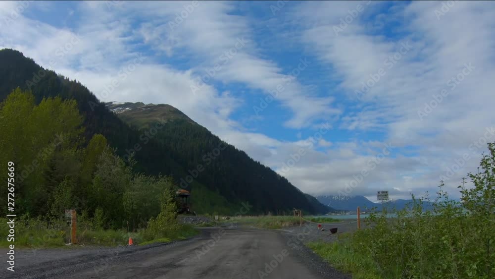POV drive on Beach Drive in Seward Alaska; derelict train car, Resurrection Bay beach and Kenai Mountains are visible. Panorama view of the sea during low tide POV drive on Beach Drive in Seward Alaska; derelict train car, Resurrection Bay beach and Kenai Mountains are visible. Panorama view of the sea during low tide