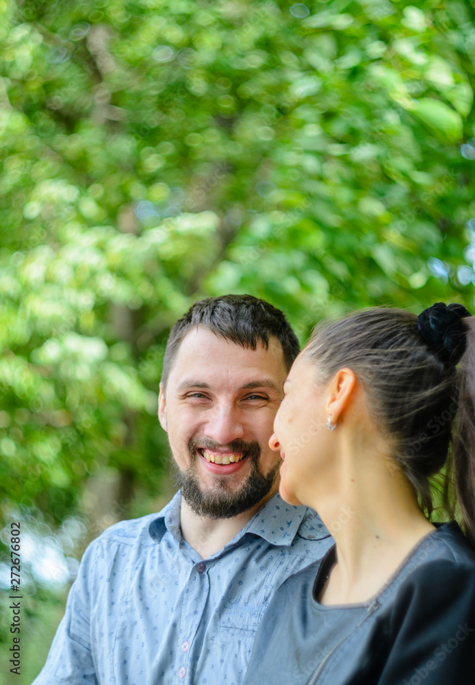 Outdoor portrait of a couple in love. Cheerful smiling couple in summer park Outdoor portrait of a couple in love. Cheerful smiling couple in summer park
