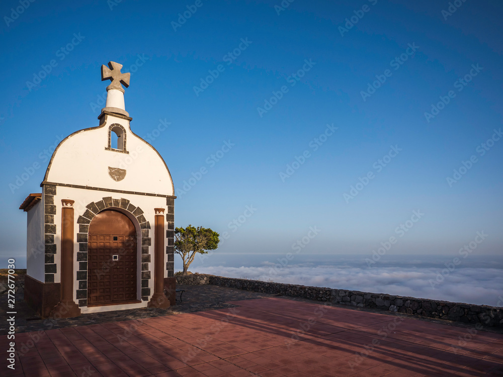 A church on top of a mountain above the clouds