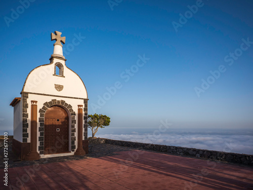 Obraz na płótnie A church on top of a mountain above the clouds w salonie
