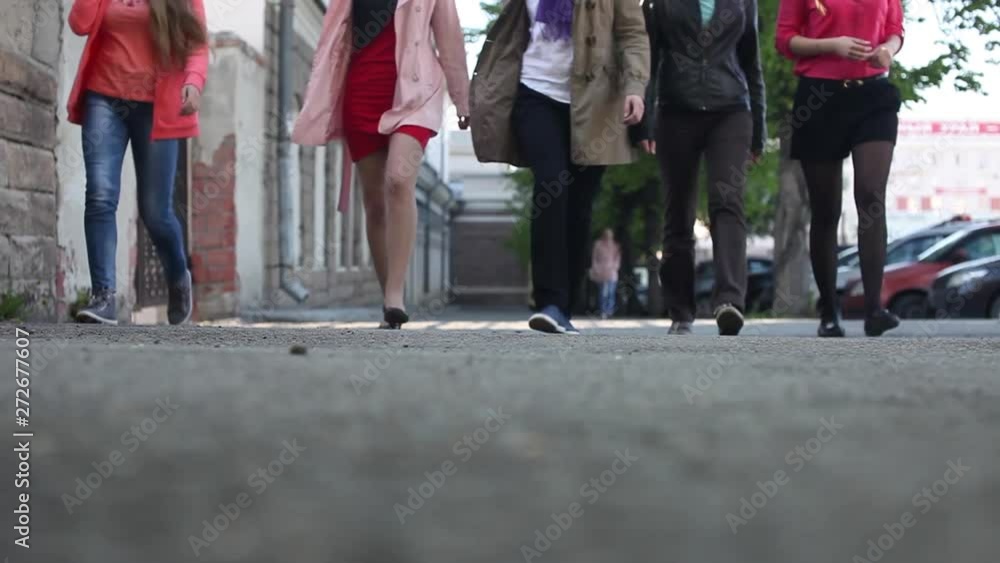 5 girls walk in a row down the street to the camera. Feet of a group of people close-up 5 girls walk in a row down the street to the camera. Feet of a group of people close-up