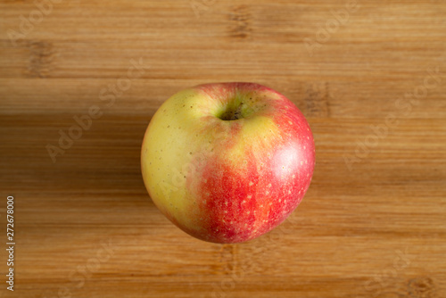 One beautiful red yellow Apple on a wooden background