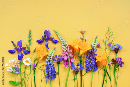 Fototapeta Naklejka Na Ścianę i Meble -  Bright frame of summer flowers on the yellow background