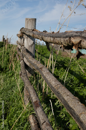 Old rustic wooden fence in the Siberian village  stretching into the distance.