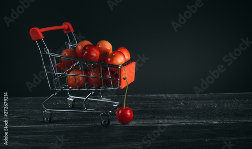 mini cart with cherries on a dark background