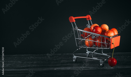 mini cart with cherries on a dark background