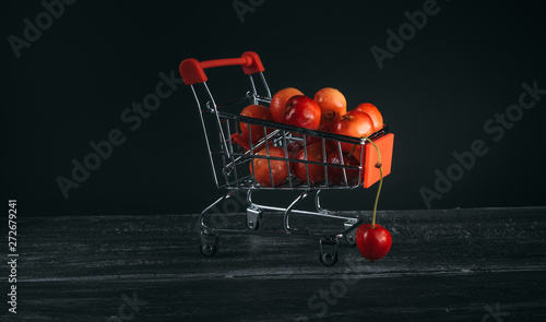 mini cart with cherries on a dark background