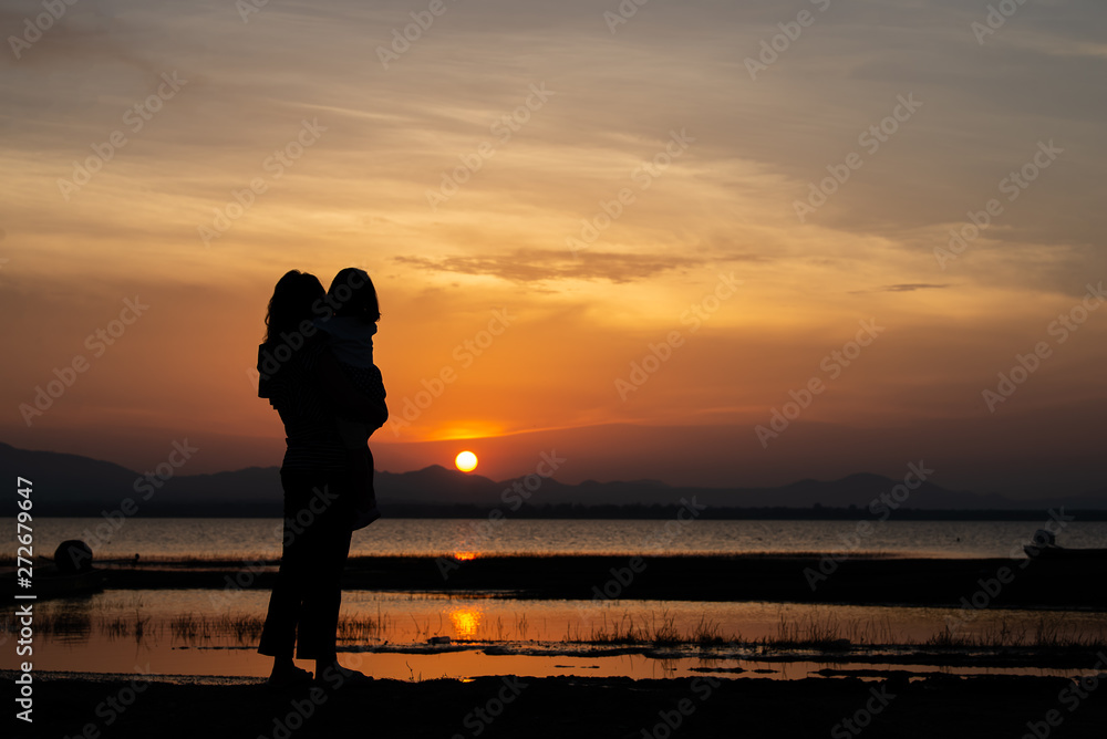 Silhouette of mother and daughter on sunset,Thailand people,Happy family concept