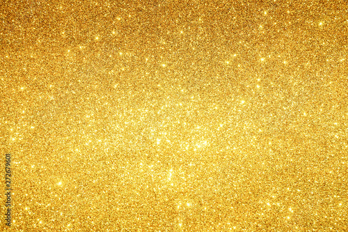 gold Sparkling Lights Festive background with texture. Abstract Christmas twinkled bright bokeh defocused and Falling stars. Winter Card or invitation photo