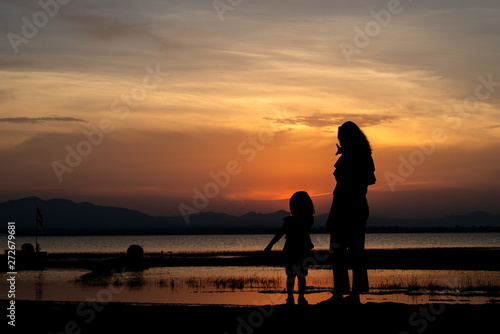Silhouette of mother and daughter on sunset,Thailand people,Happy family concept