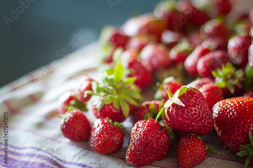 Closeup of a bunch of fresh large ripe strawberries on the kitchen table before cooking  selective focus