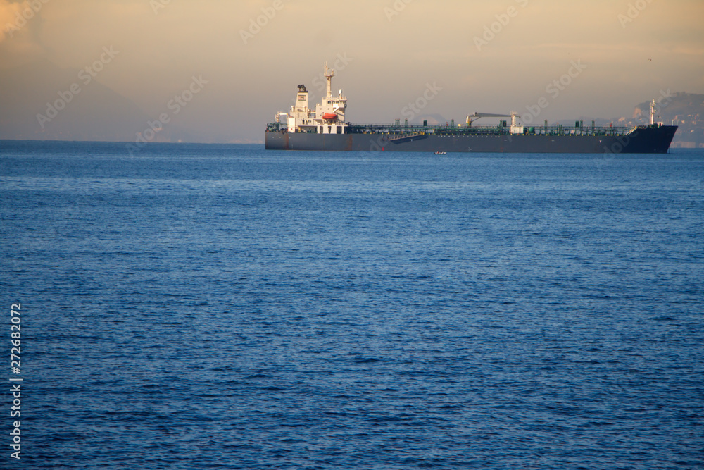 View of the huge sea liner in the harbor on the background of the sunset on the sea