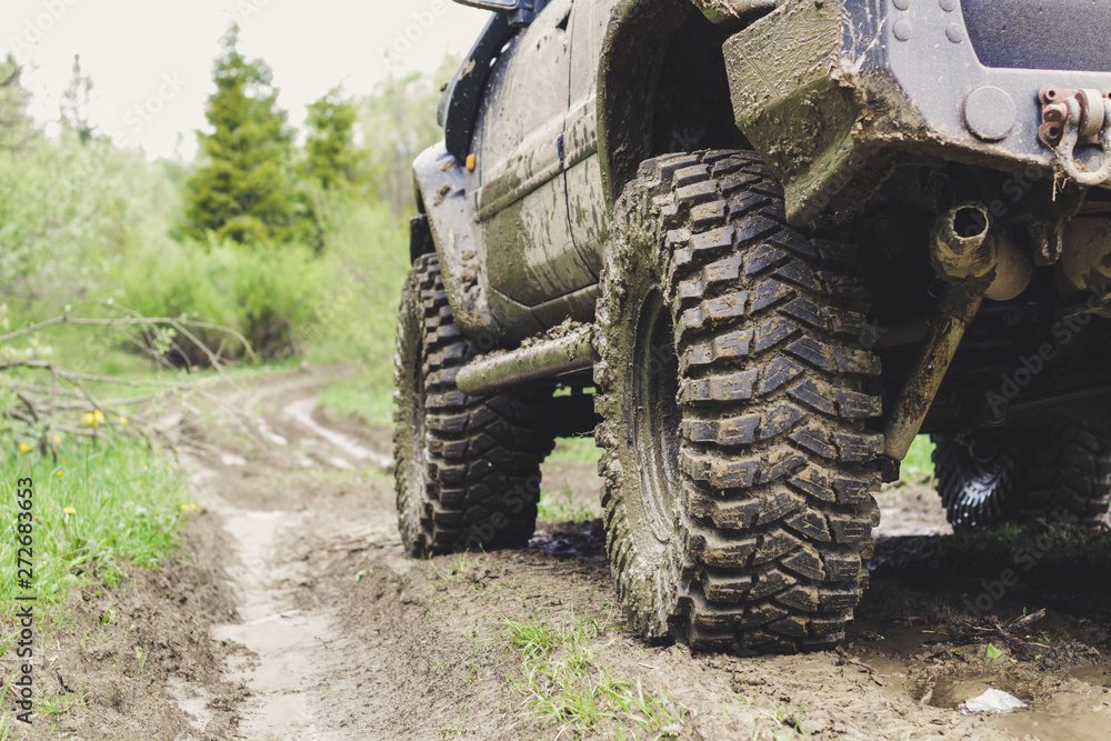 Fototapeta premium Dirty cars and wheels in the mountains. Swamp on the tires. Trips offroad across Ukraine. View of the Carpathian Mountains.