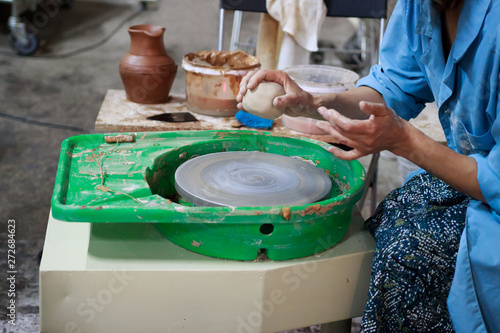 A novice student in the first lesson in pottery tries to make a product from clay on a potter's wheel. reportage