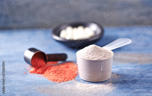 Scoop of Whey Protein, Creatine Powder and Taurine capsules. Sport nutrition. Rustic wooden background. Close up. Copy space photo