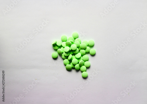 Green drug pills in pile on white background