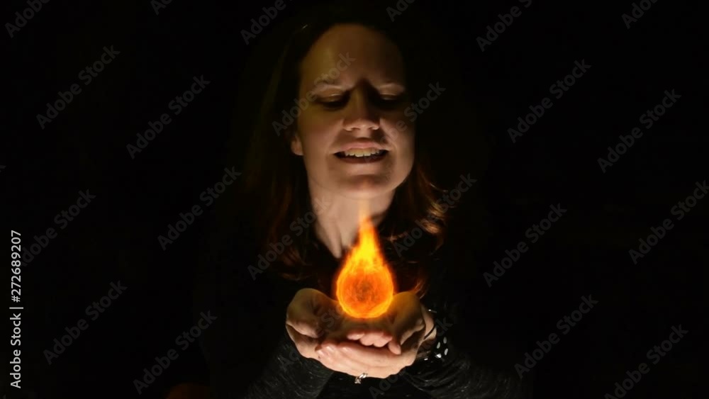 Futuristic scene of a woman with cupped hands holding a holographic projection of fire. Futuristic scene of a woman with cupped hands holding a holographic projection of fire.