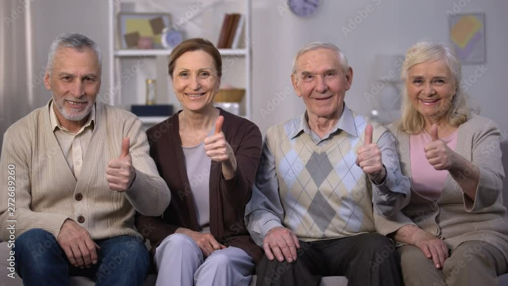Smiling elderly people showing thumbs up at camera, social reform improvement Smiling elderly people showing thumbs up at camera, social reform improvement