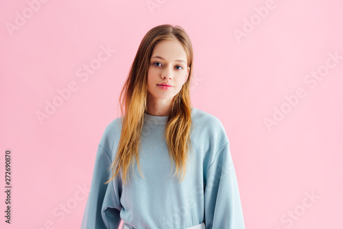 beautiful smiling teenage girl looking at camera isolated on pink photo