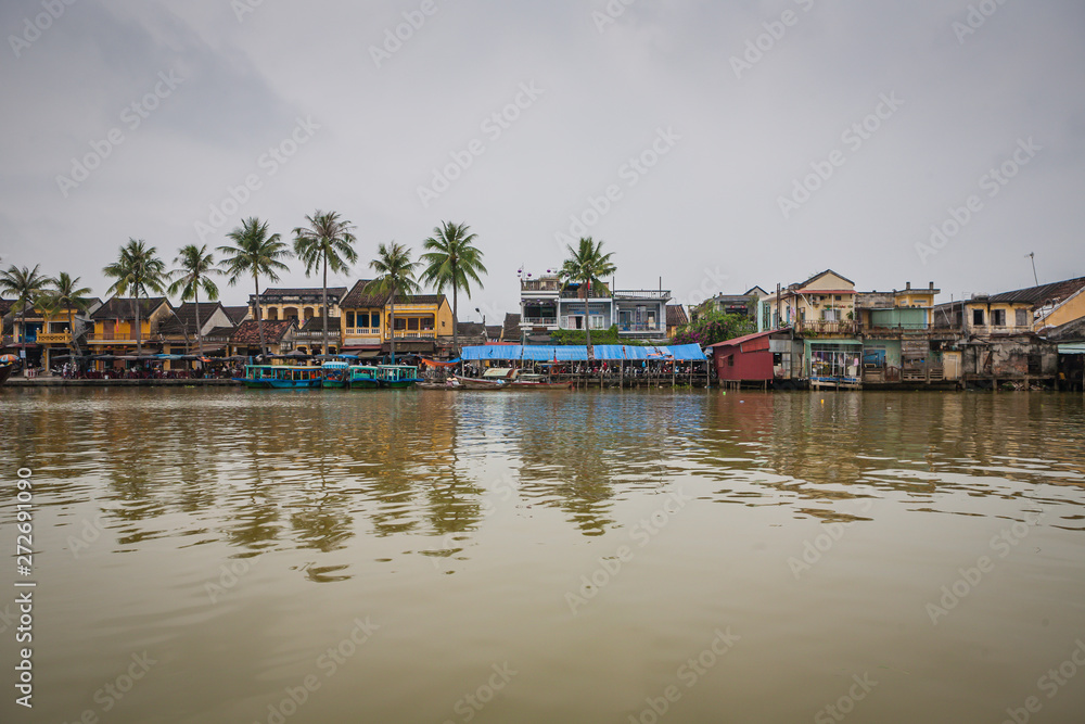 View across the river towards Hoi An, Vietnam with fishing boats moored