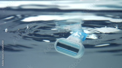 closeup of shaver immerced ino water. underwater view with water surface reflecting photo