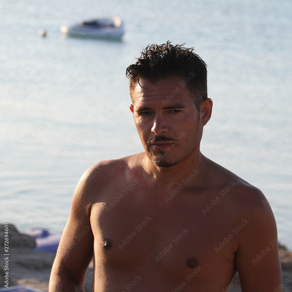 Handsome man with swimsuit are enjoying on the beach at sunset. Apulia, Salento, Italy Handsome man with swimsuit are enjoying on the beach at sunset. Apulia, Salento, Italy