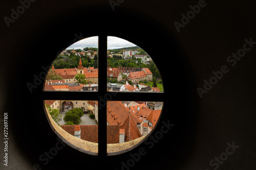 View through the window on the tower of the castle and the view of Cesky Krumlov with the famous Cesky Krumlov Castle, the Church of the World Heritage Site