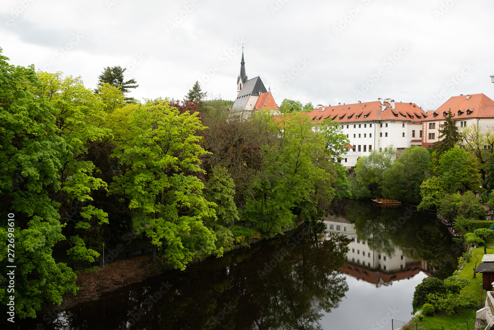 Fototapeta premium View of the Vltava River flowing through the town of Cesky Krumlov with the famous Cesky Krumlov Castle, Church of the World Heritage Site.