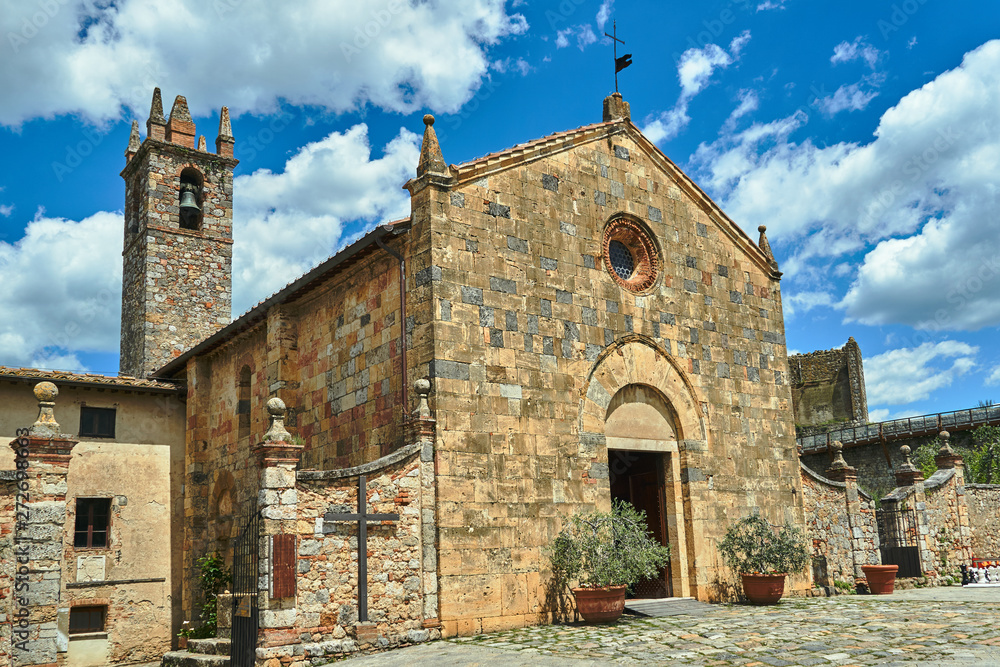 Stone, medieval church with a bell tower in the village of Monteriggioni in Toscana, Italy.