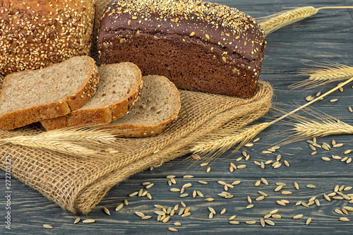 Rye bread and ears of rye on wooden table photo