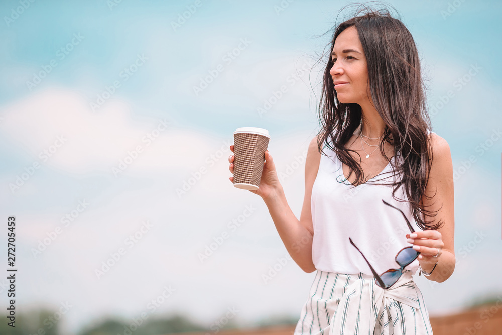 Happy young urban woman drinking coffee in european city. Happy young urban woman drinking coffee in european city.